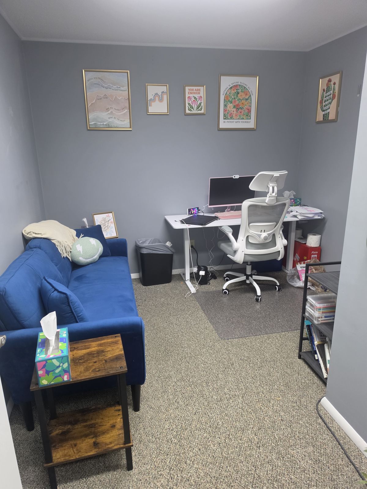 A provider office with a blue sofa and a desk
